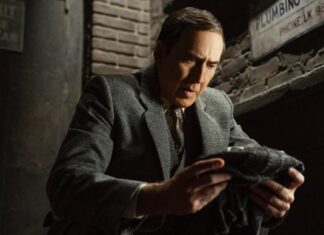 Nicolas Cage šplhá po zdi. V černobílém formátu.